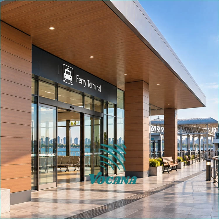 Wood-look WPC cladding and soffit finishes around a ferry terminal passenger entrance